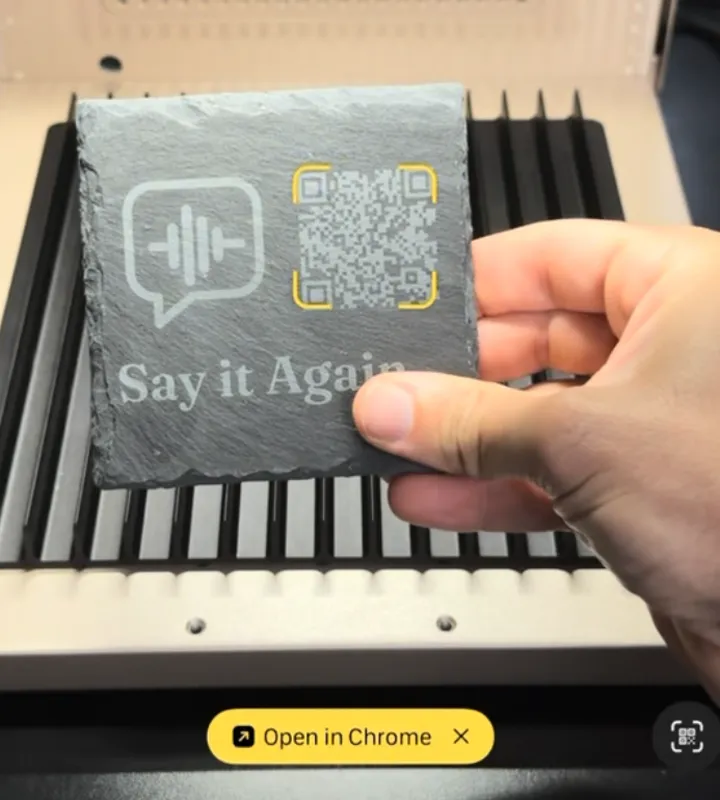The owner’s engraved slate and its working QR code, shown with a phone camera scan prompt.